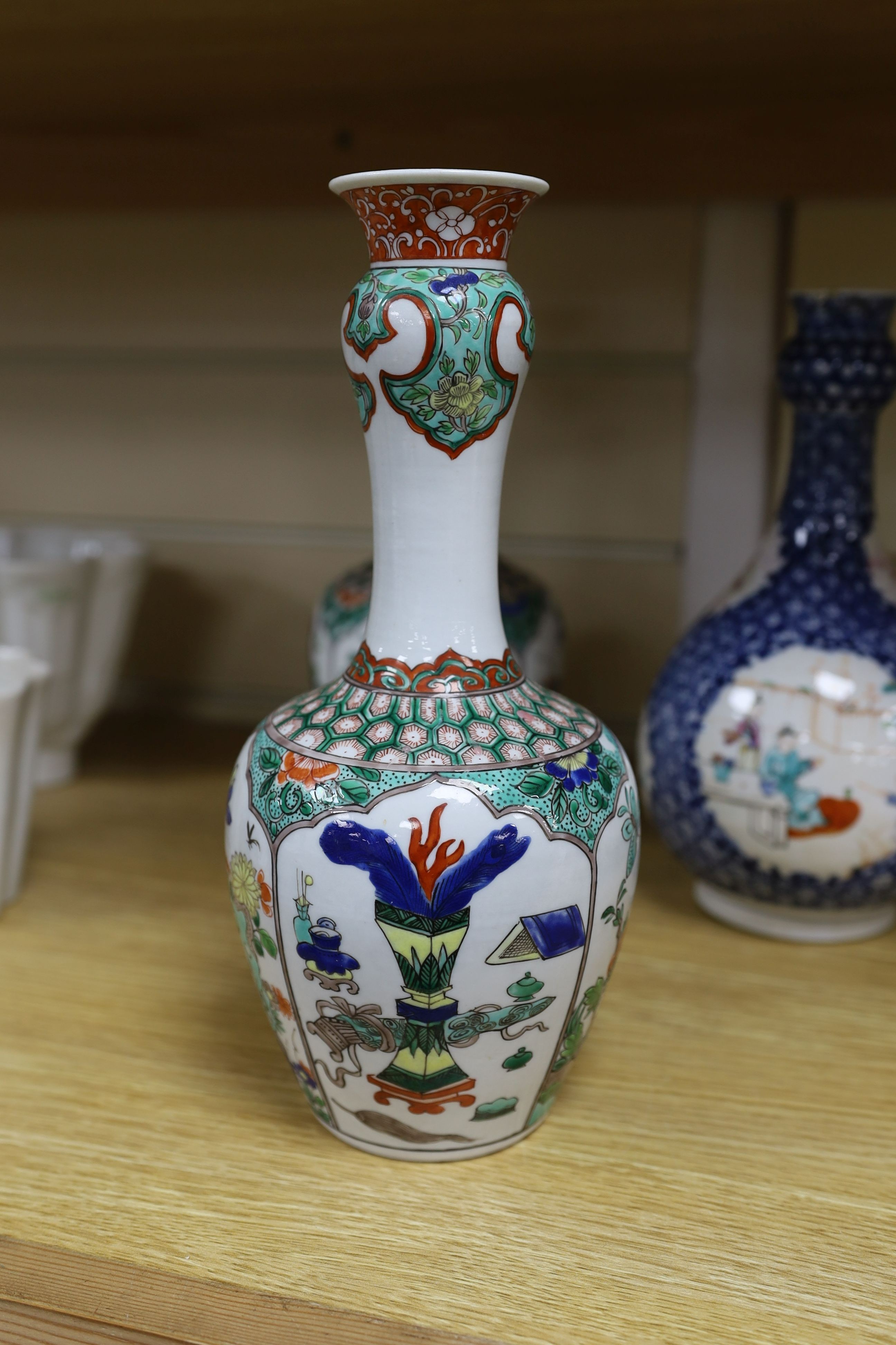 A pair Samson of Paris vases in the Chinese famille verte style and a Chinese Qianlong famille rose garlic neck vase with blue panelling motif, tallest 26cm